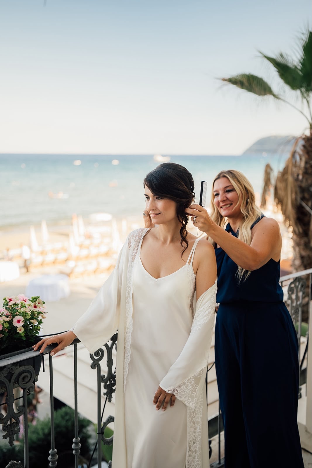 Giorgia rifinisce l’acconciatura della sposa vista mare